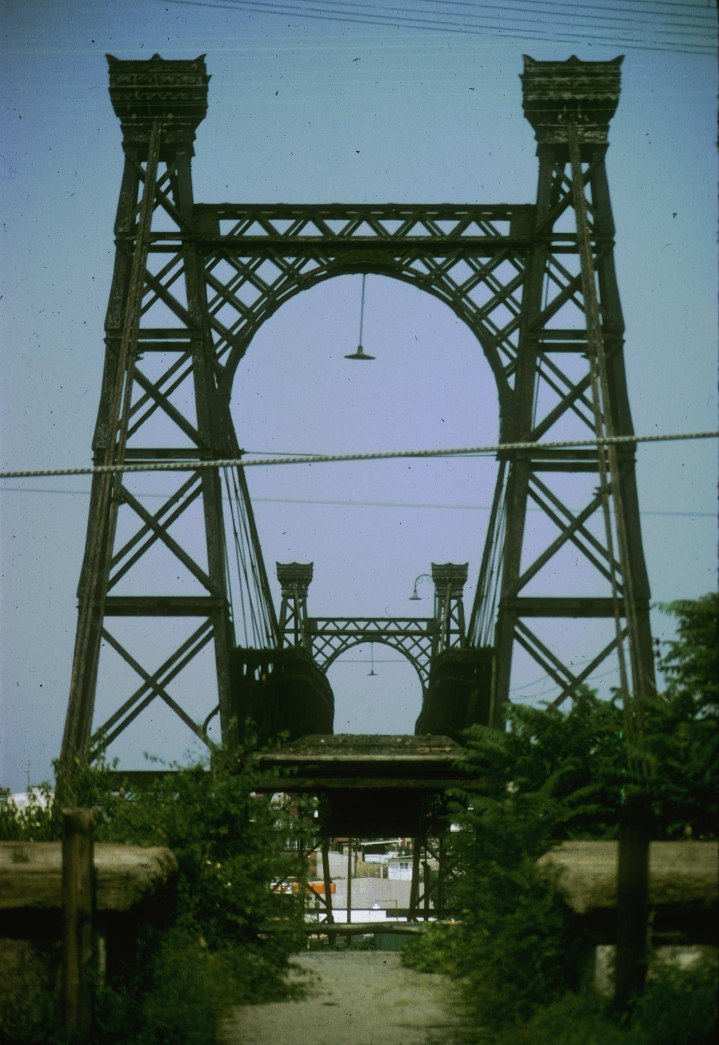 Photograph along the deck of the bridge taken from an anchorage.
